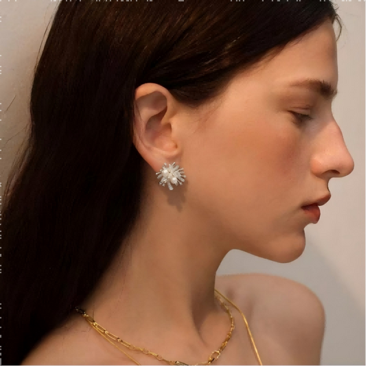 Pair of Mercury brand silver starburst stud earrings with three central pearls surrounded by sparkling clear crystals.