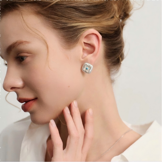 Mercury brand mother of pearl clover stud earrings with silver textured edges and a turquoise center stone.