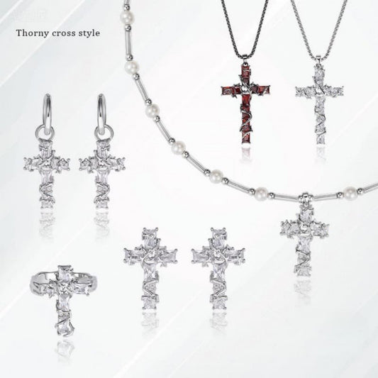 Mercury brand jewelry display featuring the Thorny Cross collection: silver crystal cross necklaces, red garnet thorn pendants, and matching gothic earrings on a minimalist background.