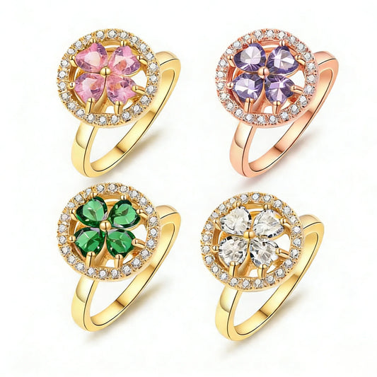 Mercury kinetic spinner ring collection in 24k gold-plated hypoallergenic stainless steel, featuring four-leaf clovers of heart-shaped AAA Zirconia stones (pink, purple, green, or clear). Designed for smooth, silent rotation to provide discreet anxiety relief.