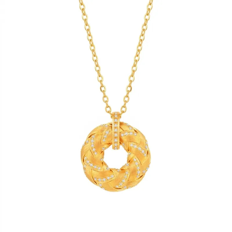 Close-up shot of Mercury brand Golden Fullness pendant necklace, featuring a braided 18K gold-plated circular design set with AAA cubic zirconia on a minimalist gold chain, isolated on a white background.