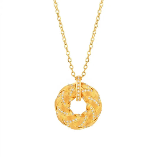 Close-up shot of Mercury brand Golden Fullness pendant necklace, featuring a braided 18K gold-plated circular design set with AAA cubic zirconia on a minimalist gold chain, isolated on a white background.