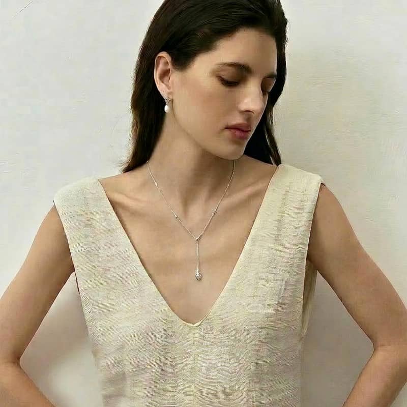 Silver lariat necklace worn on model with V-neck dress