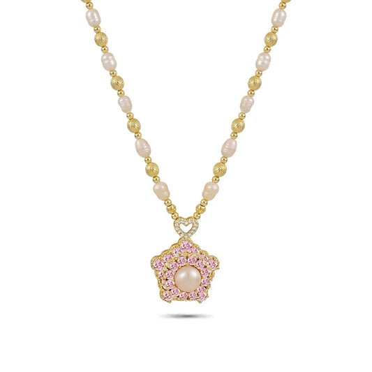 A gold-toned necklace featuring oval-shaped freshwater pearls separated by small gold beads. The centerpiece is a five-petal flower pendant encrusted with pink and white crystals, a large central pearl, and a crystal-studded heart-shaped bail.