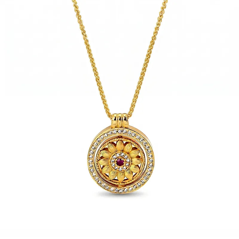Minimalist 18K gold plated sunflower spinning necklace by Mercury, featuring a dainty rotating floral pendant with a small red center stone and clear AAA zirconia accents.