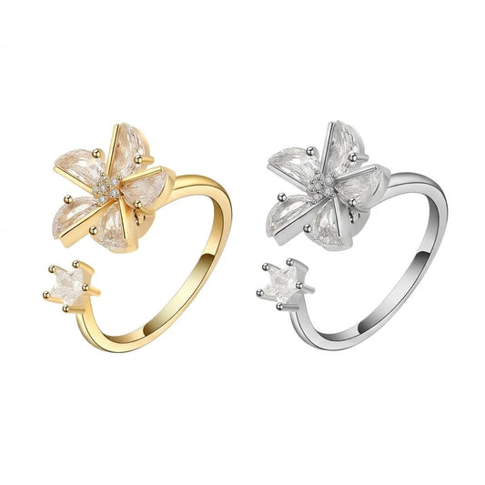 Mercury 24K gold and silver spinning rings with AAA cubic zirconia flower and star, isolated on white.