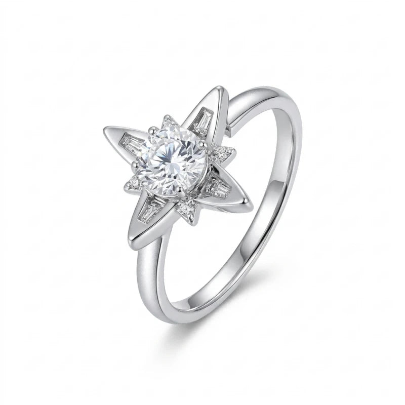 A radiant sterling silver star-shaped fidget ring with a central round brilliant Moissanite and rotating petals featuring both baguette-cut and tiny round accents. Photographed at a angled perspective on a clean white background.