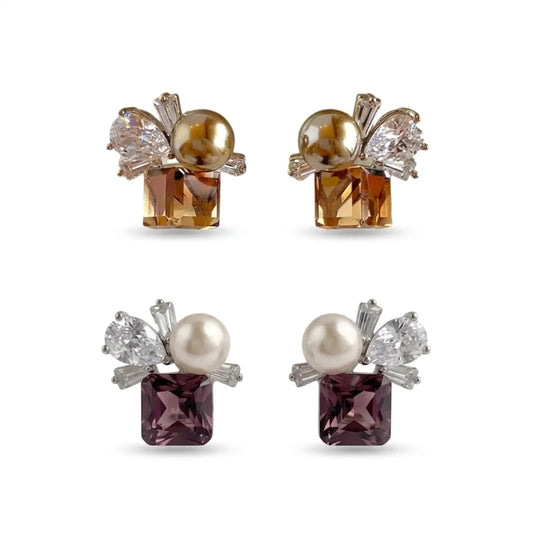 Luxury crystal and pearl stud earring collection in two colorways: champagne gold and deep purple. Modern geometric design with square-cut gemstones and pearl accents on a seamless white background for e-commerce.